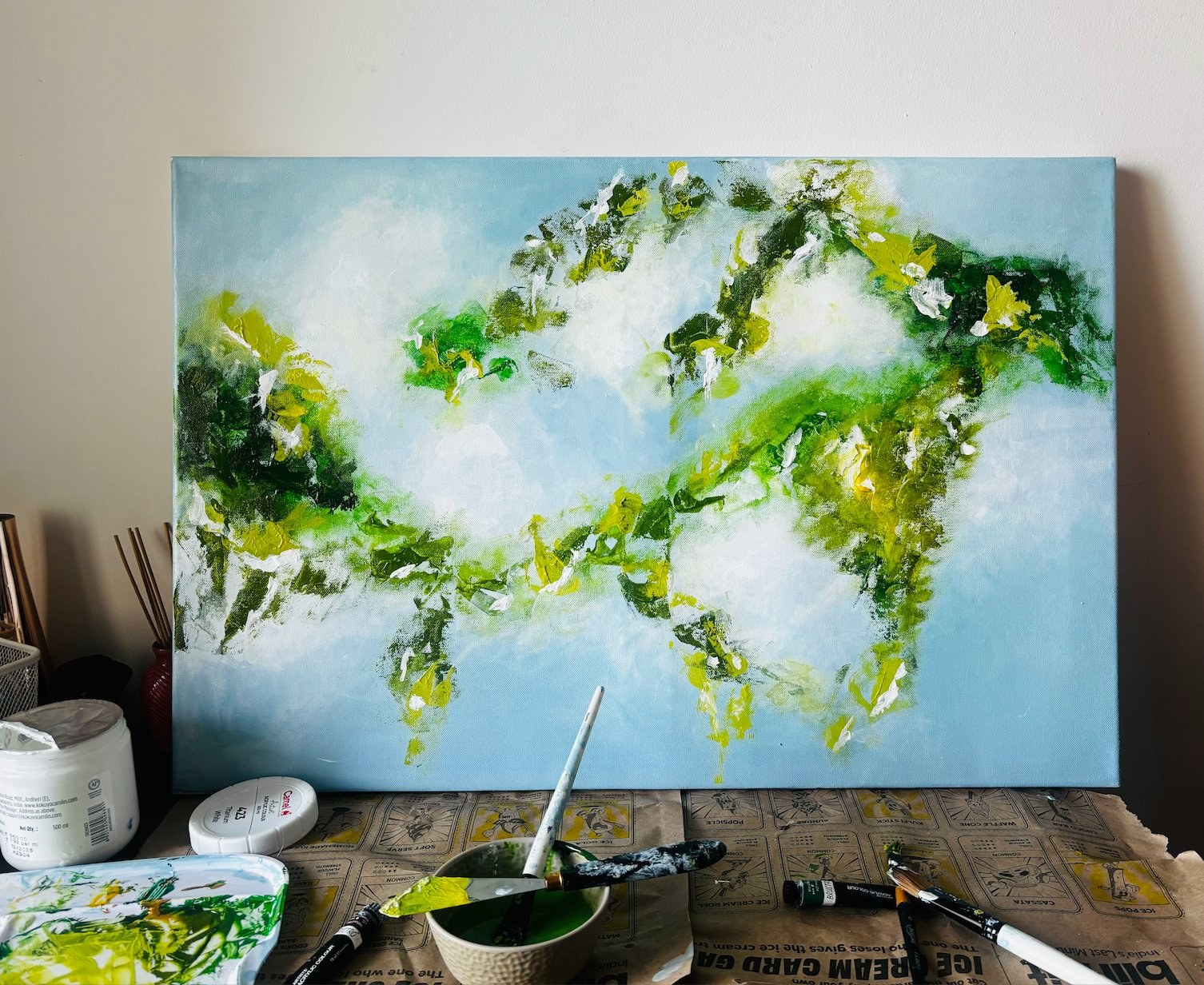 Work in progress — palette, knives and a painting taking shape